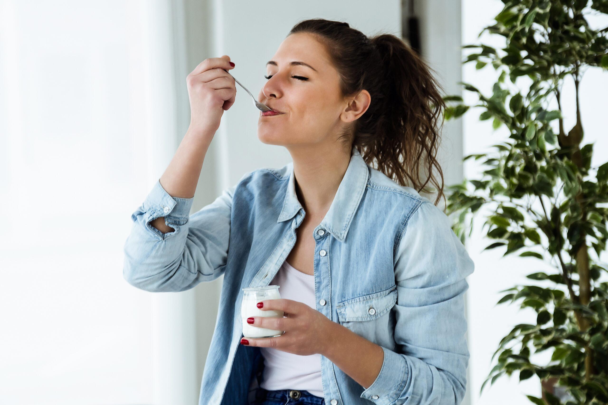 beautiful-young-woman-eating-yogurt-at-home.