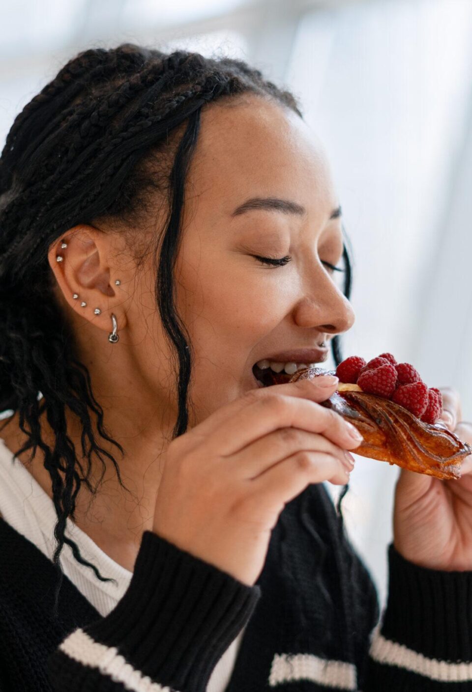 Beautiful African American woman enjoying sweet raspberry pastry in cafe Beautiful African American woman enjoying sweet raspberry pastry in cafe