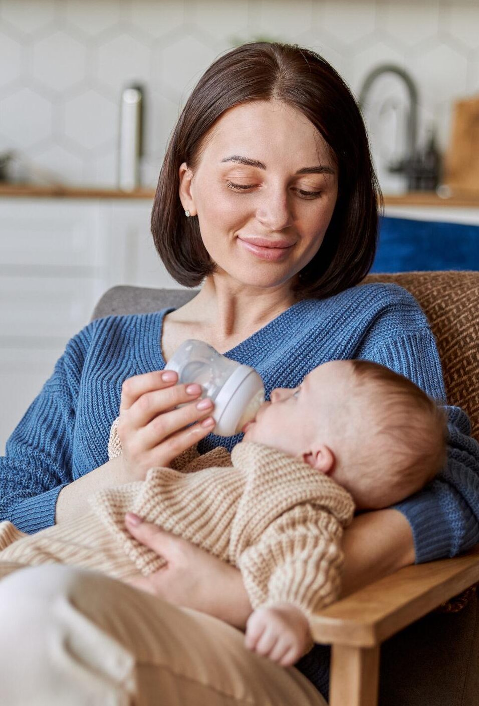 Mother feeding newborn baby from bottle with milk Mother feeding newborn baby from bottle with milk