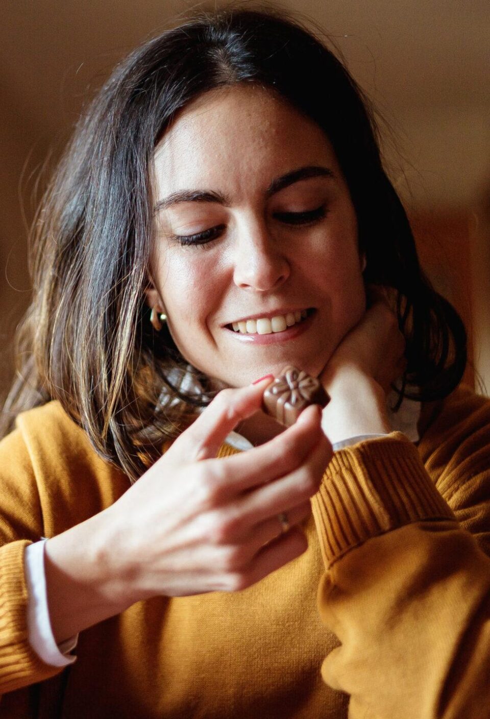 Beautiful young woman eating chocolate in candid kitchen Beautiful young woman eating chocolate in candid kitchen